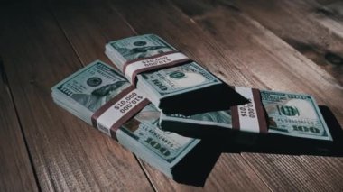 Üç deste 10000 Amerikan Doları Banknotları Tahta Masada Yatar