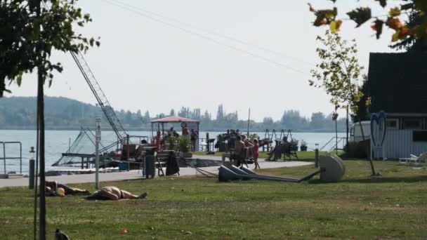 Mensen uit de omgeving Campings zijn ontspannen aan het water aan het Balatonmeer, Hongarije — Stockvideo
