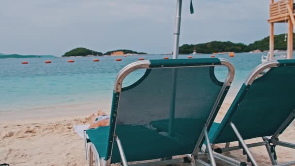 Lege ligstoelen op het zandstrand tegen de turquoise zee, Albanië, Ksamil — Stockvideo