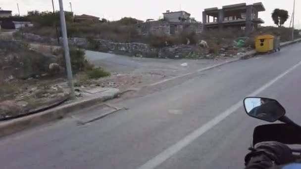 POV Biker Rides by Muddy Garbage Road in Albanië met vernielde gebouwen — Stockvideo