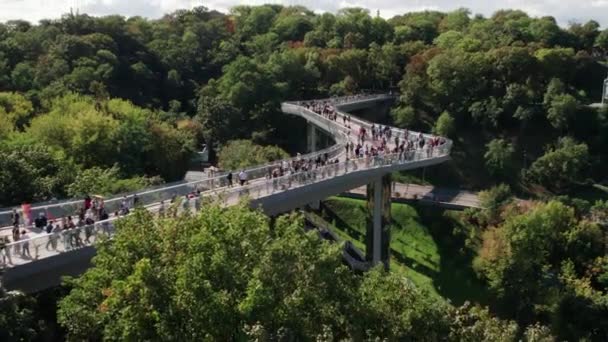 Vista aérea del puente peatonal de vidrio con una multitud de personas caminando — Vídeo de stock