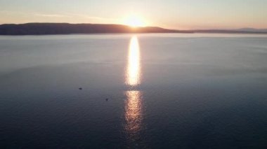 Deniz üzerinde Günbatımının havadan görünüşü Su üzerinde Yapraklar ve Parıltı