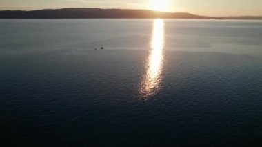 Deniz üzerinde Günbatımının havadan görünüşü Su üzerinde Yapraklar ve Parıltı