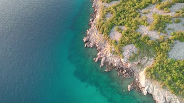 Flygfoto över Kroatiens klippiga kust med en kurva väg vid solnedgången tid — Stockvideo