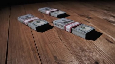 Üç deste 10000 Amerikan Doları Banknotları Tahta Masada Yatar