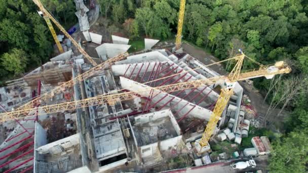 Vista aérea Construção de um novo edifício com guindastes de alta torre em área verde — Vídeo de Stock