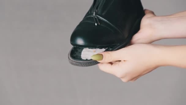 Femmina mano tiene uno stivale con una suola strappata su uno sfondo bianco, scarpe colloqui — Video Stock