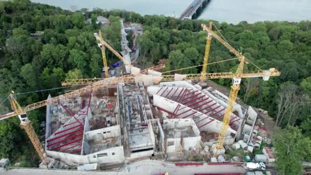 Vista aérea Construcción de un nuevo edificio con grúas de torre alta en zona verde — Vídeo de stock