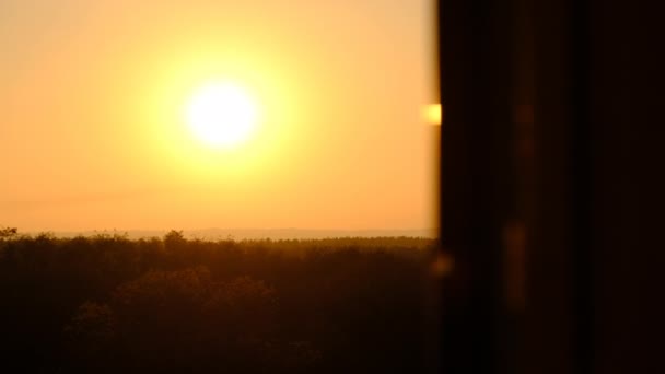 Sonnenuntergang am Himmel über dem Horizont, Blick hinter die Silhouette des Fensters — Stockvideo
