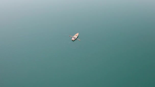 Uitzicht vanuit de lucht Eenzame houten boot in het midden van het water Oppervlakte van een bergmeer — Stockvideo