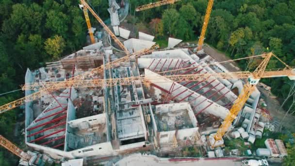 緑のエリアに高いタワークレーン付きの新しい建物の空中ビューの建設 — ストック動画