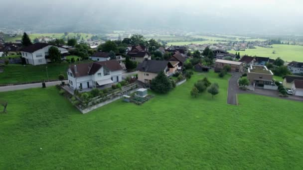 在阿尔卑斯山谷绿地上建有房屋的列支敦士登的空中景观 — 图库视频影像