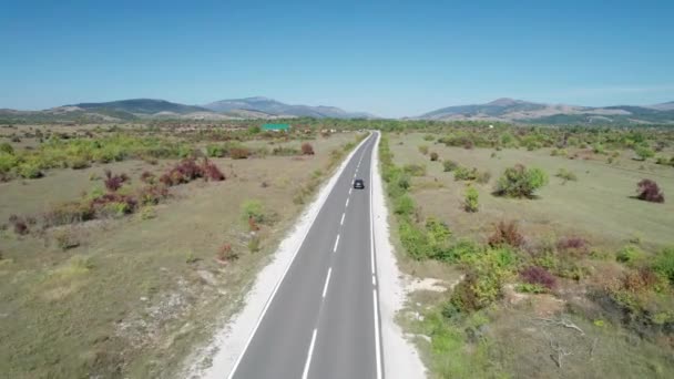 Vista aerea Strada asfaltata vuota sull'altopiano tra campi verdi, Highland Way — Video Stock