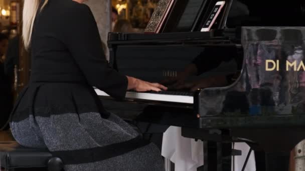 Pianista femenina toca el piano frente a un elegante restaurante en Venecia, Italia — Vídeo de stock