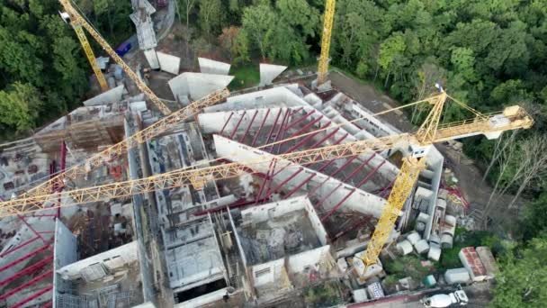 Aerial View Új épület építése magas toronydarukkal a zöld területen — Stock videók