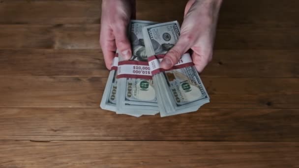 Male Hands Flipping Stacks 10000 Dollar Bills on Wooden Background, Slow Motion — Stock Video