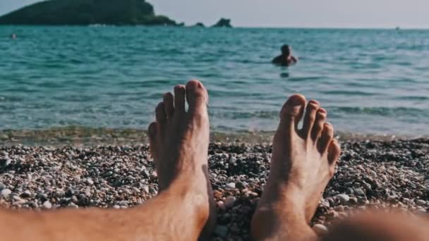 POV Jeune Homme Pieds nus sur la plage de galets au bord de la mer — Video