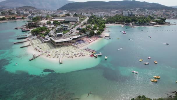 Aerial, Azure Beach com Espreguiçadeiras e Barcos Vazios, Costa do Mar dos Balcãs, Albânia — Vídeo de Stock