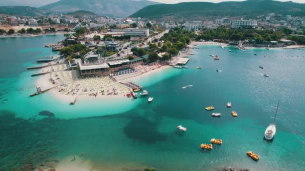 Luchtfoto, Azure Beach met lege ligstoelen en boten, Balkanzeekust, Albanië — Stockvideo