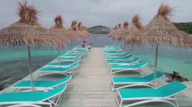 Thatched Şemsiyeleri Altında Turkuaz Denizi 'ndeki Bir İskelede Boş Güneş Yataklarının Hava Görüntüsü