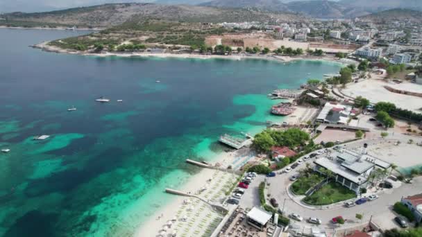 Aerial, Azure Beach com Espreguiçadeiras e Barcos Vazios, Costa do Mar dos Balcãs, Albânia — Vídeo de Stock