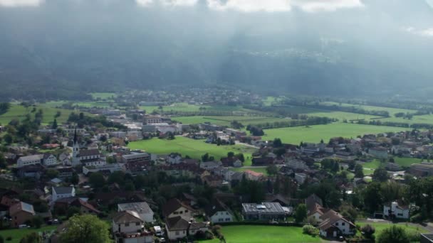 Luchtfoto van Liechtenstein met huizen op groene velden in het Alpendal — Stockvideo