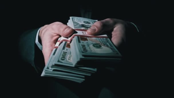 Trois piles de 10000 dollars américains faisceaux en mains masculines sur fond noir — Video