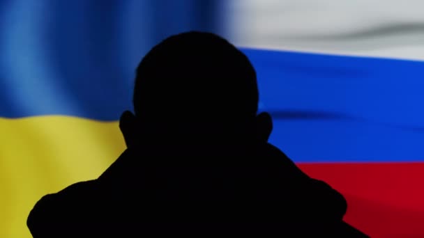 Silhouette dell'uomo contro le bandiere di Ucraina e Russia, Confronto — Video Stock