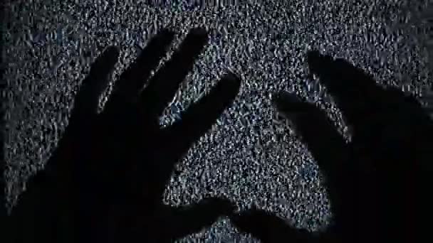 静的ホワイトテレビノイズで古いテレビ画面に触れる手のシルエット — ストック動画