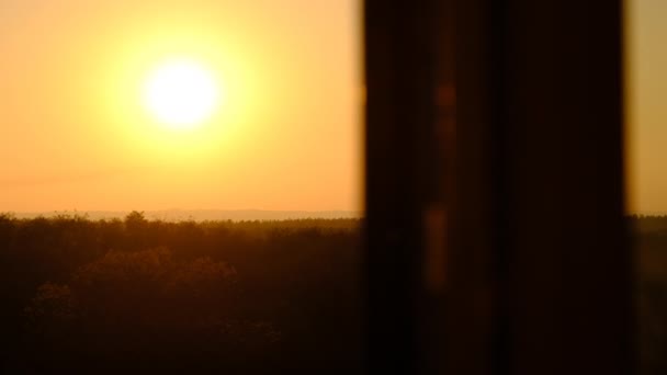 Puesta de sol en el cielo sobre el horizonte, vista desde detrás de la silueta de la ventana — Vídeos de Stock