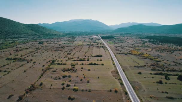 Camino de asfalto vacío en la meseta entre campos verdes, vista aérea de Highland Way — Vídeo de stock