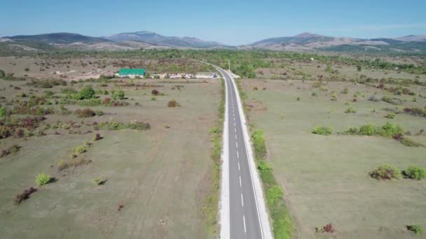 Tomme asfaltveier på platået mellom grønne jorder, Highland Way Aerial View – stockvideo