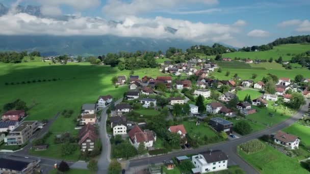 Légi kilátás Liechtenstein házak zöld mezők az Alpok Mountain Valley — Stock videók