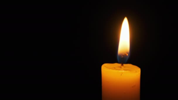Plamen svíčky na černém pozadí, zblízka — Stock video