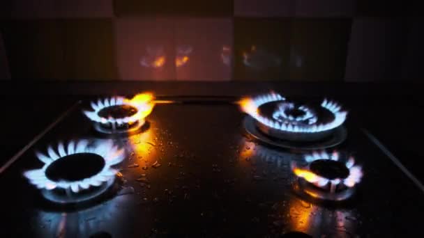 Cuatro quemadores de gas se queman simultáneamente en una estufa de gas en la oscuridad — Vídeo de stock