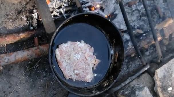 Вертикальные кадры - Жареная свиная отбивная в масле в сковороде над огнем на открытом воздухе — стоковое видео