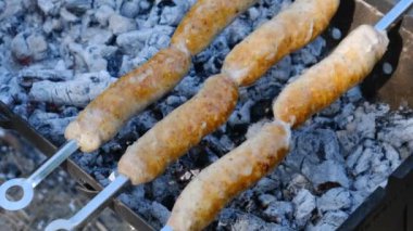 Sosisler portatif ızgarada pişiriliyor. Kapatın, barbekü.