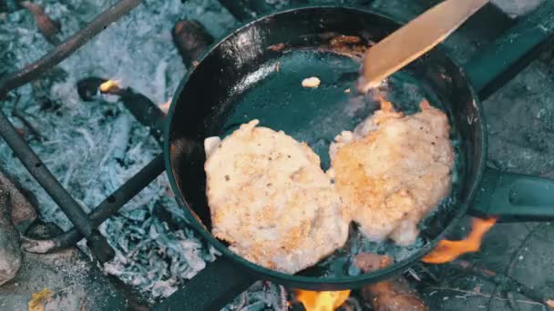 Smažené vepřové kotlety v oleji v pánvi na ohni venkovní, vaření tučné maso — Stock video