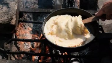 Doğada Turist Kızartma Tavasında Kamp ateşinde omlet pişirmek