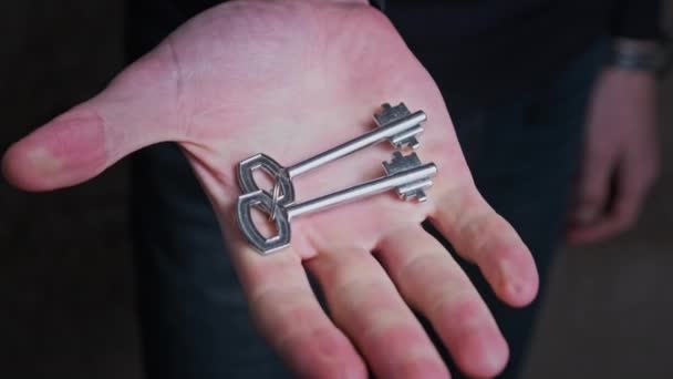 Ключи спрятаны в кулаке мужской руки — стоковое видео