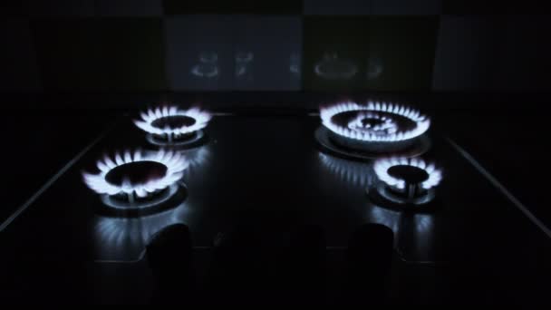 Четыре газовых горелки горят одновременно на газовой плите в темноте — стоковое видео