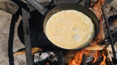 Doğada Turist Kızartma Tavasında Kamp ateşinde omlet pişirmek