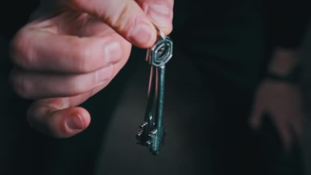 Männliche Hand, die der Kamera die Hausschlüssel zeigt, in Großaufnahme — Stockvideo