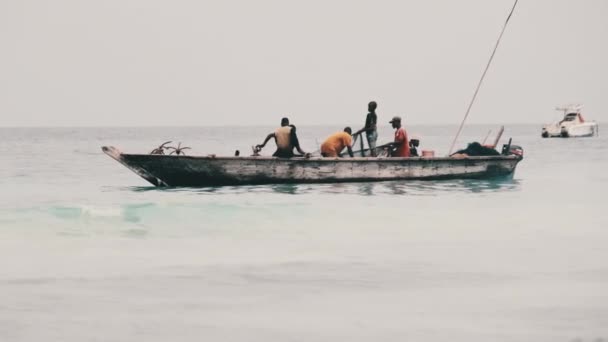 Afrykańscy rybacy na drewnianej łodzi Ryby w oceanie przy użyciu sieci rybackiej, Zanzibar — Wideo stockowe