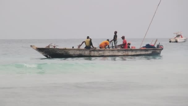 Afričtí rybáři na dřevěné lodi Ryby v oceánu pomocí rybářské sítě, Zanzibar — Stock video