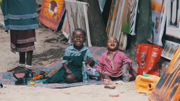 Lokal afrikansk grimy glad pojke och flicka sitta på marken, lek och leende, Zanzibar — Stockvideo