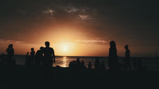 Sylwetki osób grających w siatkówkę plażową o zachodzie słońca, wolny ruch, Zanzibar — Wideo stockowe