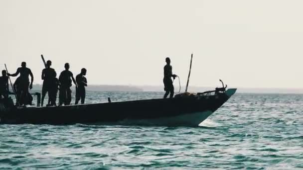 Drôle de danse pêcheurs africains sur bateau à moteur en bois flottant par l'océan, Afrique — Video