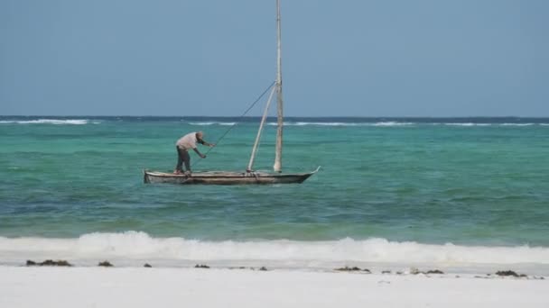 Afrikansk fiskare på en gammal torr träbåt segla i havet vid High Tide, Zanzibar — Stockvideo