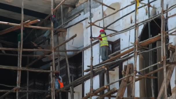 Constructores africanos reconstruyen un edificio en ruinas en Stone Town, Zanzíbar, África. — Vídeos de Stock